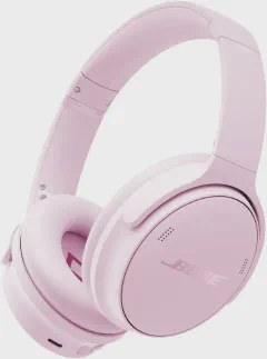 Bose QuietComfort over-ear noise cancelling headphones in petal pink, placed on a tray table with a boarding pass and a laptop